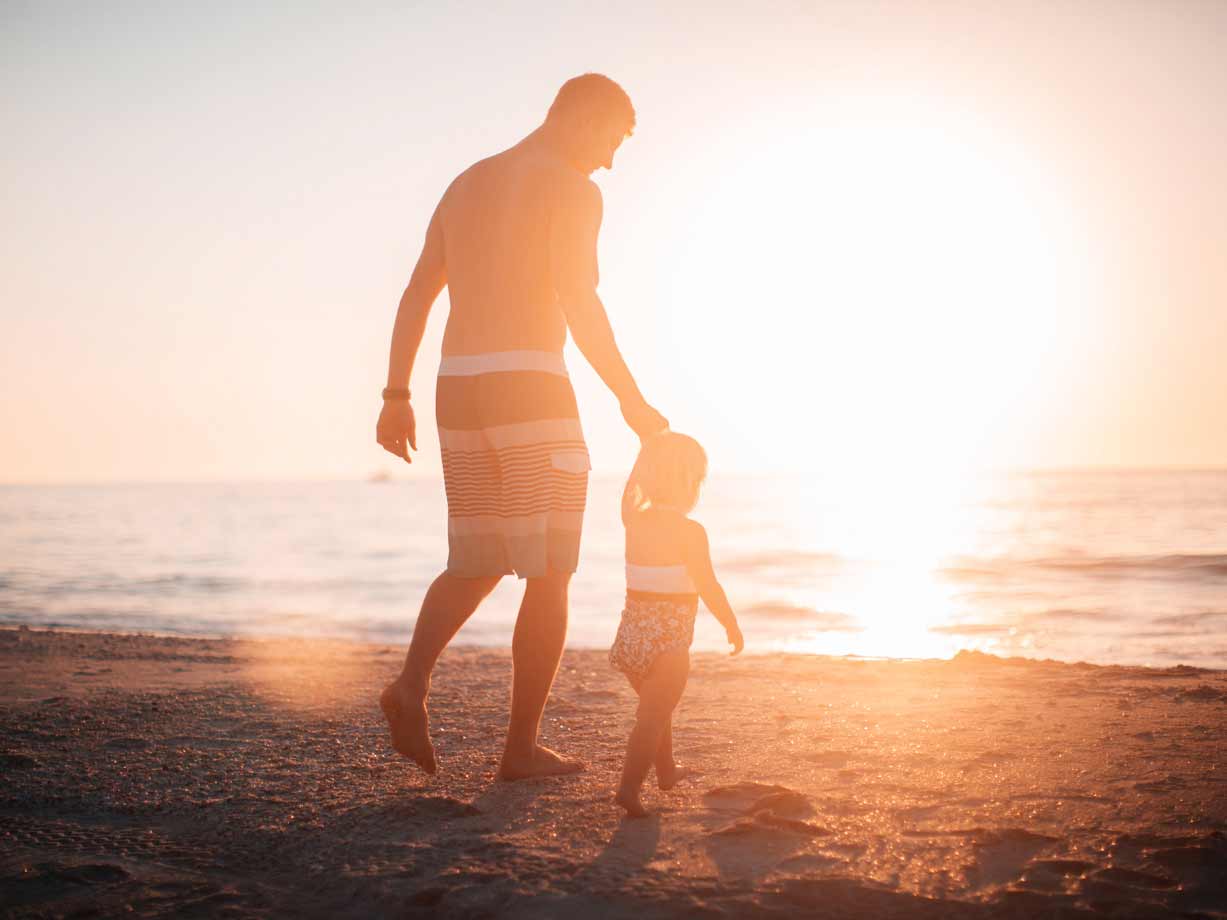 Father walking on the beach with daughter